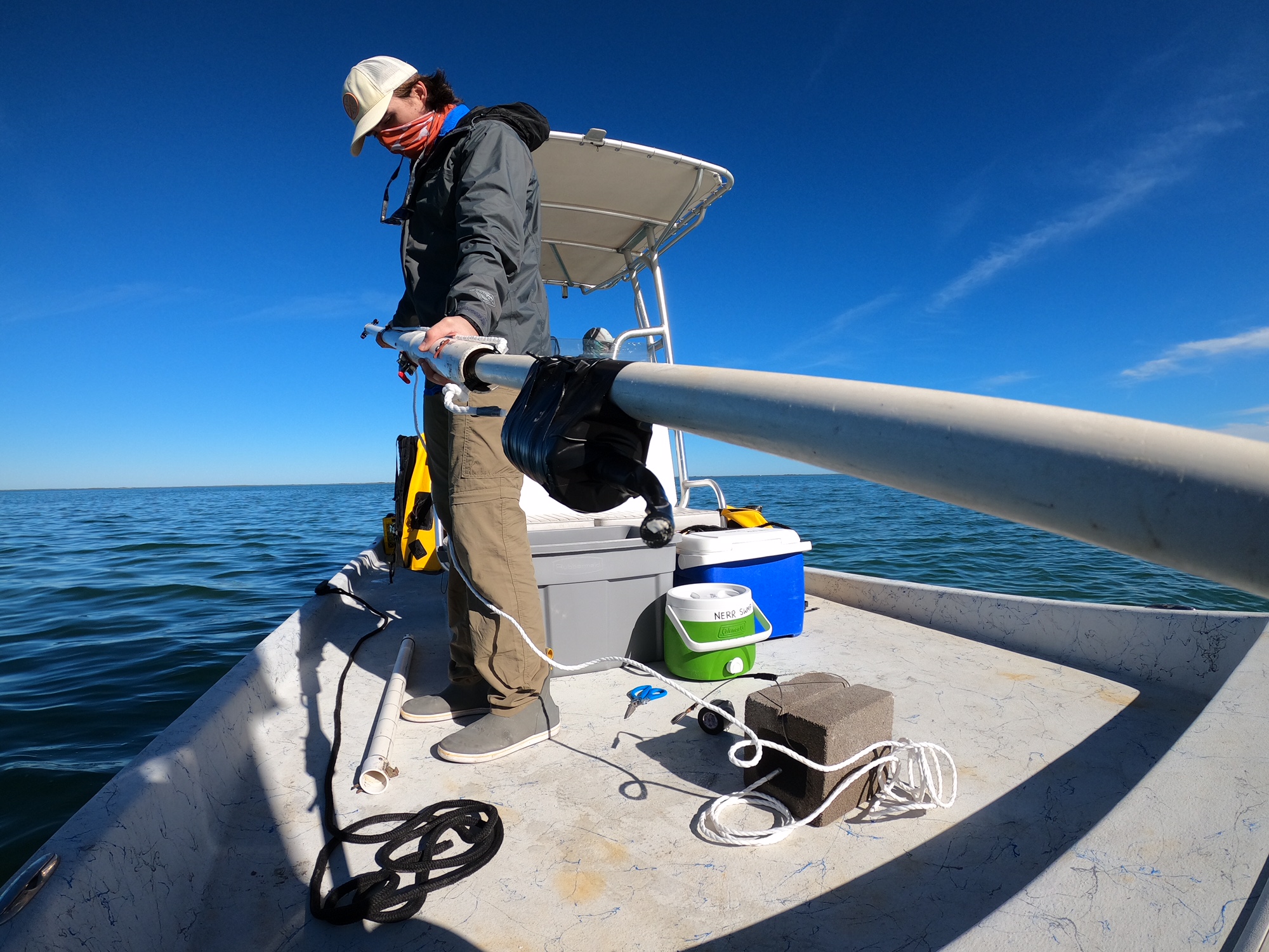 Fellow assembling equipment on a boat in the ocean.